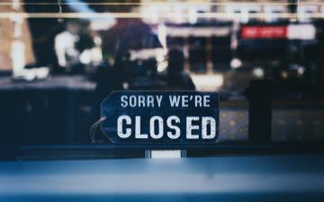 close-up of sorry we're closed sign on glass window