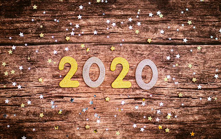 Gold and silver cutouts of the year 2020 with small stars surrounding it.