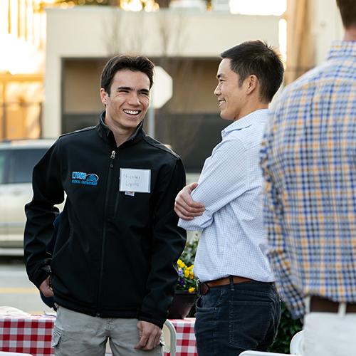 Two men talking and smiling