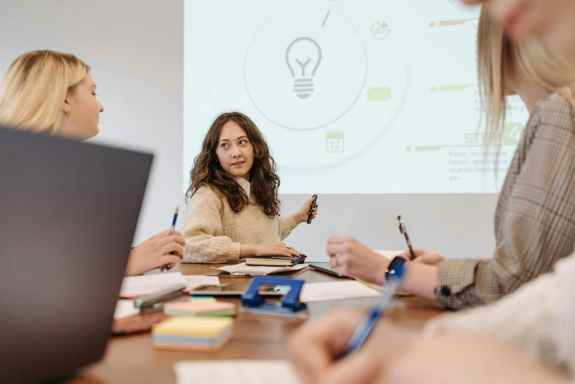 Diverse team of young professionals engaged in a collaborative meeting or brainstorming session in a modern office setting