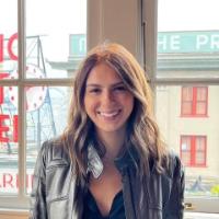 A woman smiling in front of a window.