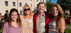 Four people smiling at Bronco Legacy BBQ event.
