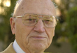 An elderly man wearing glasses, in an outdoor setting. image link to story