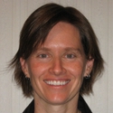 Smiling person with short hair and a light-colored background. image link to story